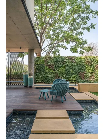 This outdoor seating area is surrounded by a vertical garden and a tranquil water body. We use landscape design to create distinct zones that offer different ways to experience and enjoy the connection to nature.