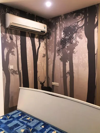 A silhouette of a deer in a misty forest creates a calm and peaceful ambiance in this bedroom. I carefully positioned the design to work with the existing furniture and AC unit.