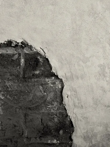 A close-up of the intentionally distressed wall finish, revealing the brickwork beneath. This technique adds a sense of history and character to the space.