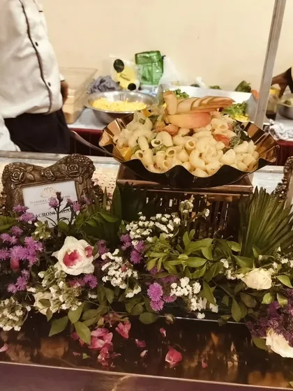 A macaroni salad dish nestled in a bed of fresh flowers, demonstrating how I integrate decor into my food presentation.