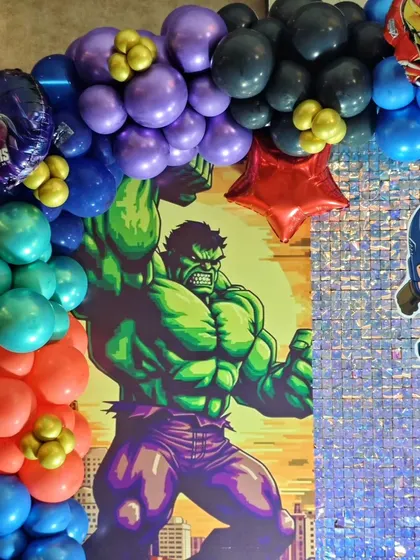 A close-up of the balloon arch from the superhero party, featuring a Hulk-themed backdrop panel.