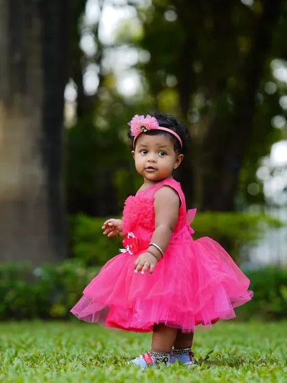 A lovely candid shot of a toddler in a pink dress, captured mid-step during her outdoor photoshoot. I focus on capturing these natural, unposed moments.
