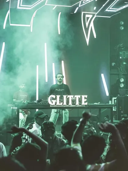 The stage at Glitte is flooded with green smoke and neon lights, creating an otherworldly atmosphere.