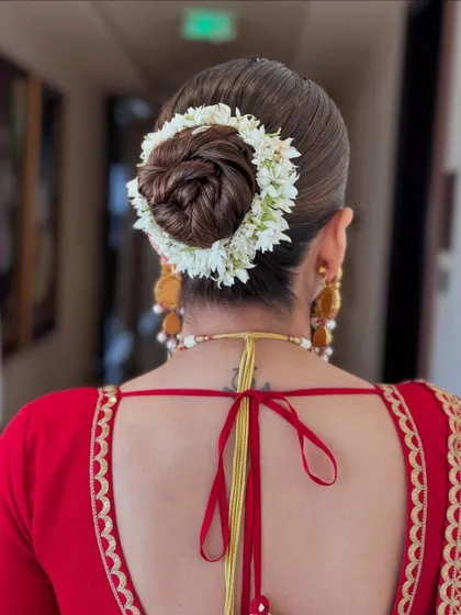 A classic bridal bun wrapped in a traditional white gajra, a timeless choice for any bride.