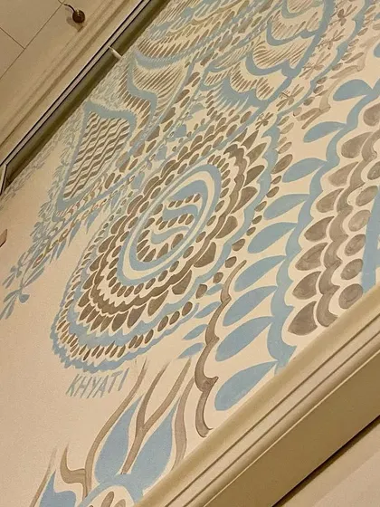 A close-up showing my signature on the Delhi mural. The fine lines and delicate patterns in silver and aqua blue create a look that is both intricate and understated.