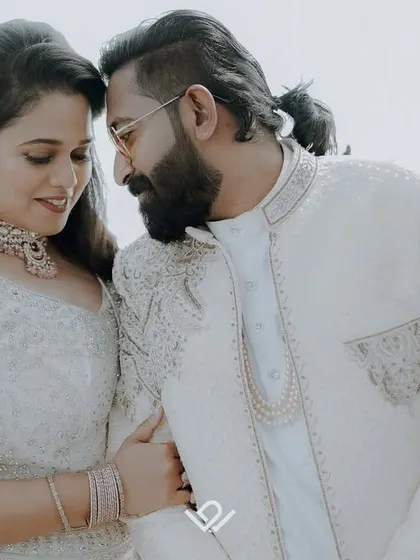 An intimate close-up of a couple by the sea, their white outfits creating a clean and romantic aesthetic.