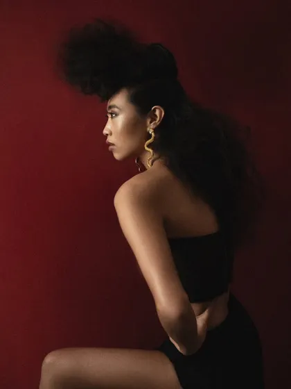 A profile shot that emphasizes the silhouette of the avant-garde hairstyle. The soft lighting creates a timeless, elegant feel even in a modern concept.