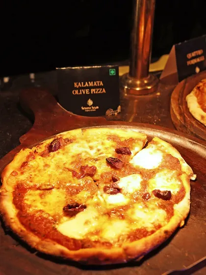 A Kalamata Olive Pizza, fresh from our live pizza station. We offer a variety of gourmet pizza toppings to elevate this classic comfort food.