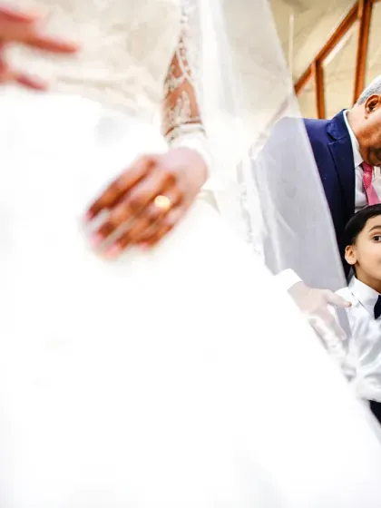 A young page boy looks up in awe at the bride. The wonder in his eyes is a beautiful, candid moment.
