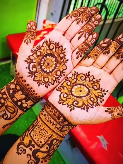 A vibrant and beautiful party mehndi design. The central mandala uses different shading techniques to create depth, and the wrist pattern complements it perfectly.