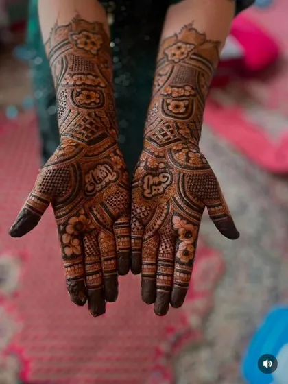 A full hand design with Arabic-style floral patterns and the name 'Afreen' written in Hindi on the palm.