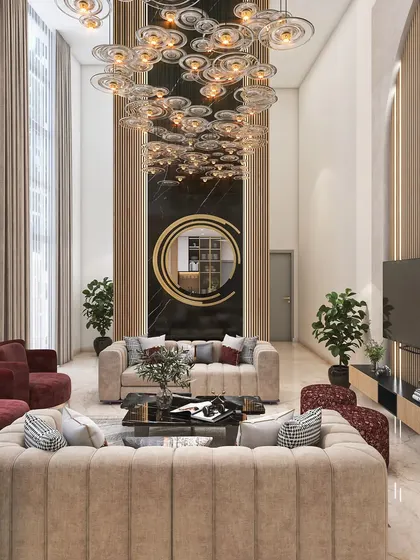 This double-height living room is the definition of grandeur. A massive, cascading chandelier hangs from the ceiling, illuminating the plush cream and maroon sofas below. This is luxury interior design at its finest.