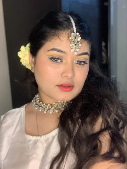 A soft and ethereal look with yellow eyeshadow and a white outfit.