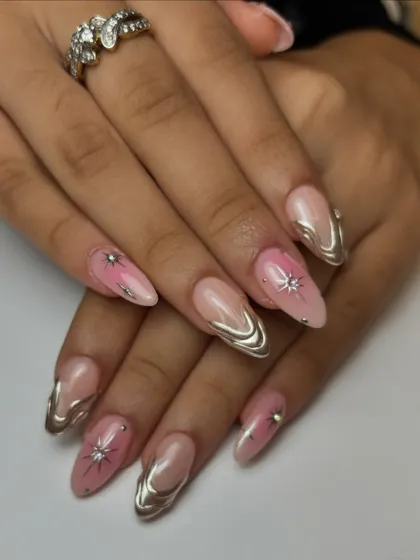 The full view of the pink ombre and chrome nails. The mix of chrome-accented nails and nails with sparkling star gems creates a balanced and stunning set.