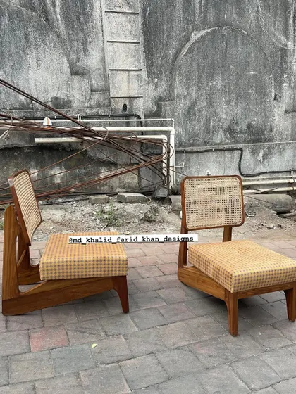 A similar low-seated chair design, this time with a cane backrest and a checkered yellow seat cushion. This is another classic Pierre Jeanneret inspired piece.