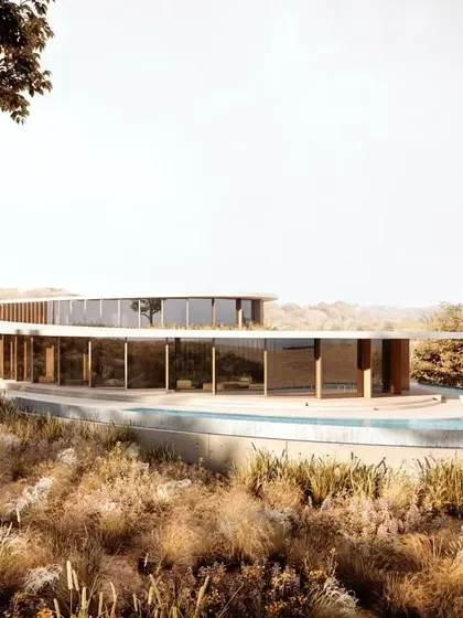 The villa's glass facade reflects the surrounding landscape, further integrating the building into its natural context.