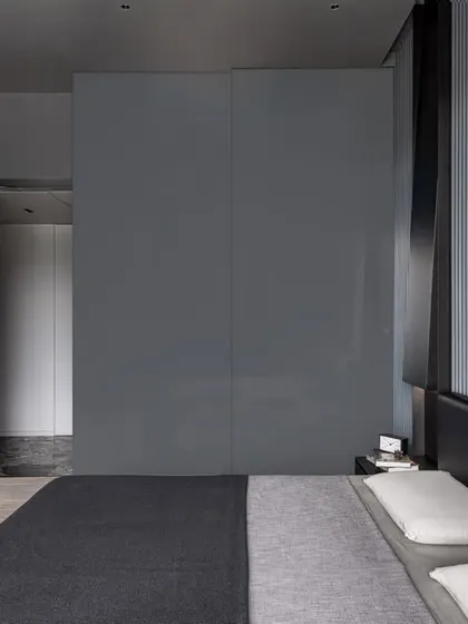 The son's bedroom, featuring a headboard wall of grey ribbed wooden slats and integrated storage.