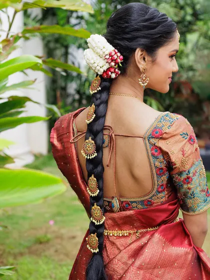 A beautiful hairstyle for a half-saree ceremony. This traditional braid is adorned with intricate gold accessories and fresh flowers for a classic and elegant finish.