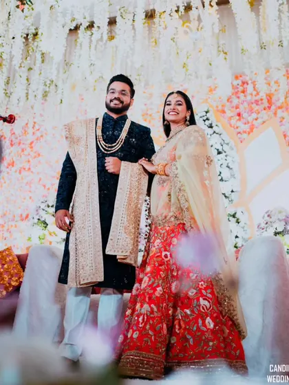 A low-angle shot of the couple on their reception stage, making them look grand and celebratory.