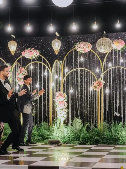 A fun performance by the groom's friends at the sangeet, set against a backdrop of sparkling lights and floral arches.