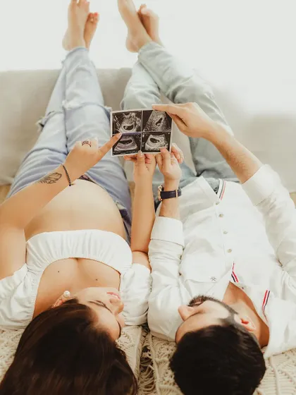 A creative and fun shot from a lifestyle maternity session, with the couple showing off their sonogram pictures. This is a wonderful way to announce and celebrate their growing family.