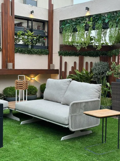 This view showcases the layered design of a terrace garden, with hanging plants, wall planters, and floor planters creating depth and a sense of being enveloped in nature.