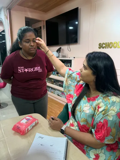 Guiding a student on the correct finger placement for applying product gently around the delicate eye area.
