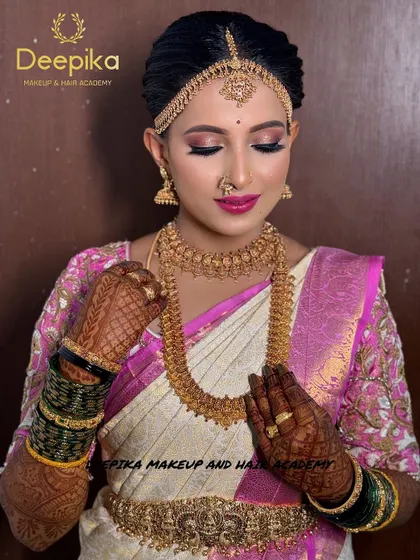 A beautiful bride ready for her big day, featuring a white and pink saree, intricate henna, and perfectly matching jewelry.