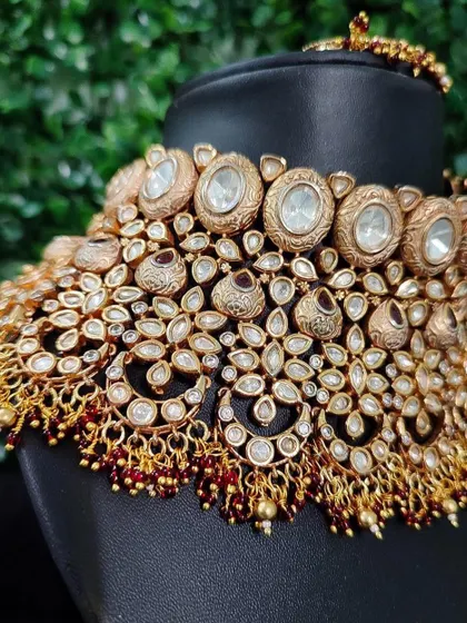 A detailed shot of the heavy kundan choker from image 13. This view shows the density of the stonework and the rich red bead accents.