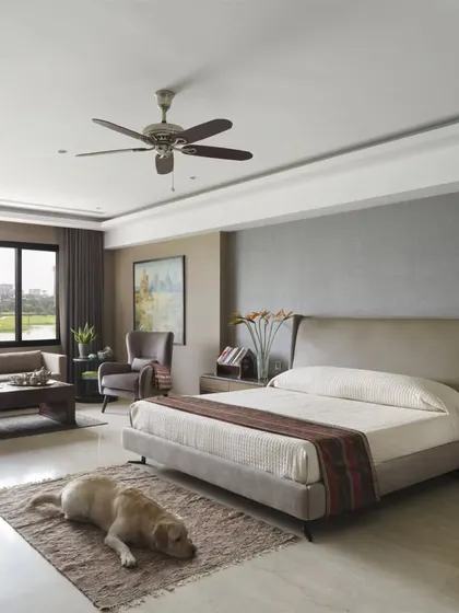 Another view of the spacious master bedroom in the Caitriona apartment, where a comfortable seating area is arranged by the large windows. The client's beloved dog finds a peaceful spot, illustrating our belief that a well-designed home is for every member of the family.