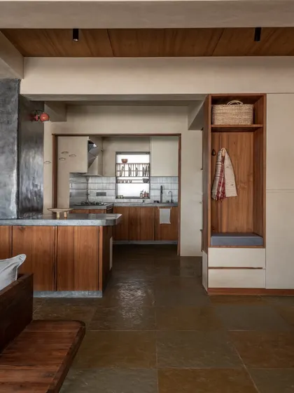 A view from the living area into the kitchen, showing the seamless transition between spaces. The built-in entryway storage nook adds functionality without disrupting the open, airy feel.