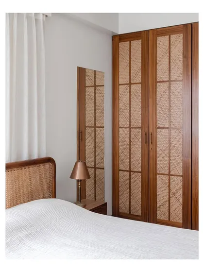 This bedroom features a custom wardrobe with rattan paneling and a matching caned headboard. I enjoy using different weaving techniques and natural fibers to create a cohesive, textured, and warm environment.