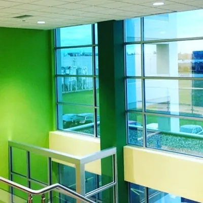 The interior of a commercial building with vibrant green walls. I can execute bold color schemes for businesses looking to create a strong brand identity in their workspace.