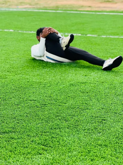 A player performs a knee-to-chest stretch, an important exercise for lower back and hip flexibility. This is part of our comprehensive cool-down routine.