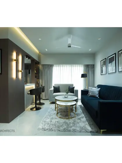 A full view of the Tulsi Heights living room, showcasing the arrangement of the sofas, coffee tables, and the open connection to the breakfast bar and kitchen.