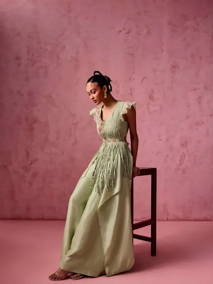 A mint green fusion outfit with flared pants and a fringed, draped top. This look is light, airy, and incredibly chic, perfect for a daytime Mehendi or a resort wedding.
