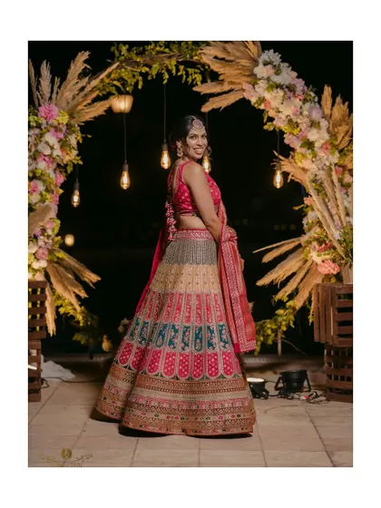 A full-length portrait of the bride against the beautiful, warmly lit reception decor.