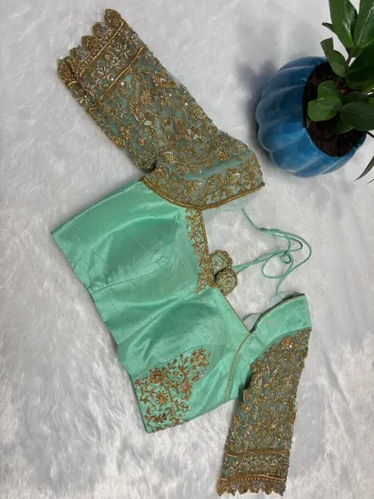 The full view of the pastel green blouse, showing the contrast between the simple body and the detailed sleeves.