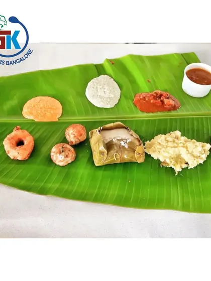 A simple yet complete meal for a pooja. This spread includes kadubu, vada, and other traditional items served on a fresh banana leaf.