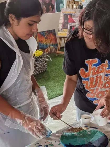 Our founder, Nisha, helping a participant with her resin art piece. We're all about providing hands-on guidance and support to ensure you love what you create.