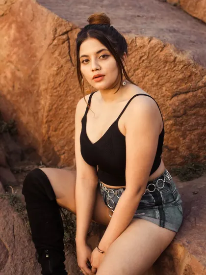 A portrait set against the rugged, earthy tones of the Aravalli hills during golden hour. The warm light complements the natural landscape, creating a grounded and powerful image.