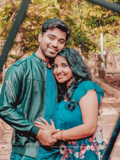 A classic, happy couple portrait. Their comfortable embrace and bright smiles show the easy love they share.