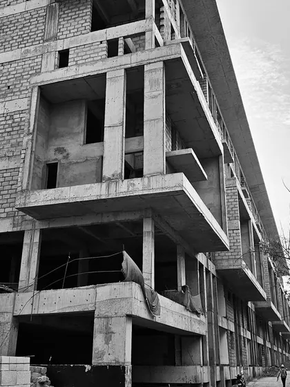 Black and white site photos documenting the construction of the SBR Earth & Sky project in Bangalore, capturing the raw concrete structure and powerful forms.