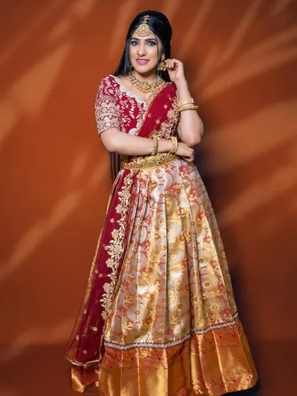 The grace of a Langa Voni is unmatched. This beautiful half saree in traditional red and gold brocade is perfect for pre-wedding functions, giving you a look that is both youthful and deeply rooted in our culture.