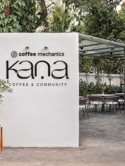 The entrance to Kana Cafe, a community space I designed to be an urban retreat inspired by the breezy, nature-integrated cafes of Bali. The design focuses on creating a tranquil atmosphere with a clean, minimal aesthetic and lush greenery.