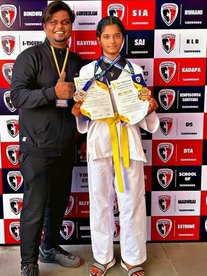 A double medalist showing her certificates and medals, a testament to her skill in multiple Taekwondo disciplines.