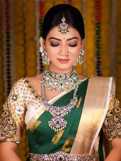 A moment of quiet elegance before the reception. This photo captures the beautiful makeup, with shimmery eyelids and flawless skin, creating a look of serene beauty.