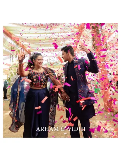 A high-energy shot of the couple dancing amidst a shower of pink confetti. This image is full of movement, color, and joy, perfectly capturing the carnival spirit.