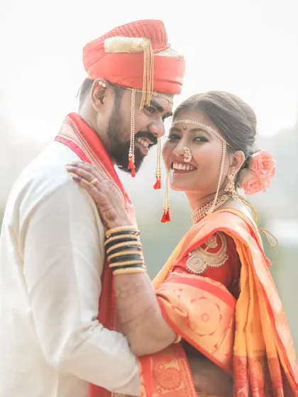 A beautiful, happy portrait where the bride is looking at the camera while the groom looks at her. It captures their love and her radiant joy.