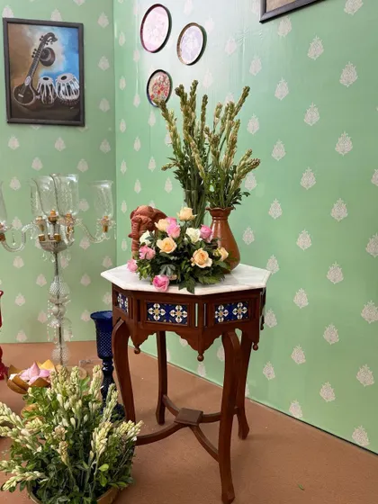 A corner of the naming ceremony room, showing the careful placement of antique furniture and floral details.